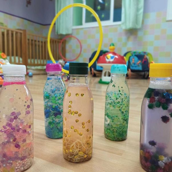 Centro de Educación Infantil Zarapeques tarros pequeños con liquido al interior de un aula infantil 